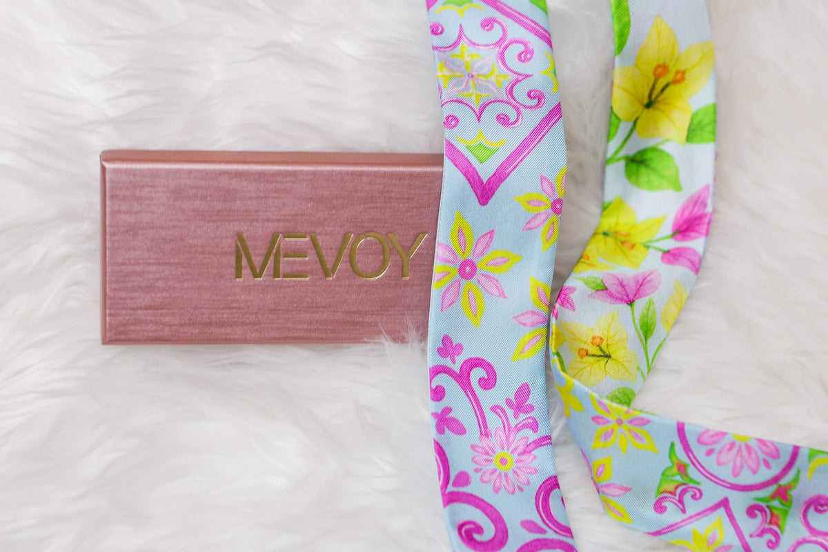 Caixa de oferta MEVOY cor-de-rosa com logótipo dourado e dois MeSilk em seda de Como sobre pelo branco