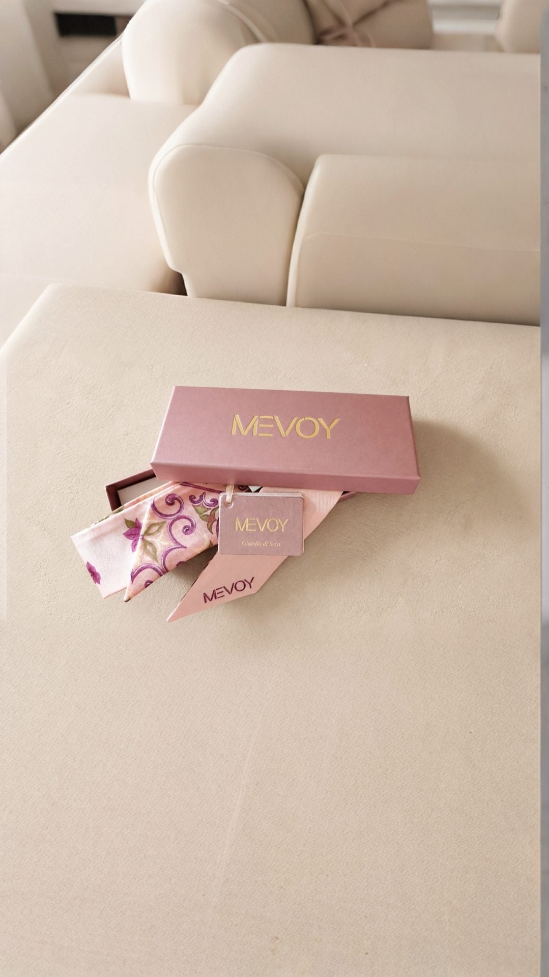 Rosa MEVOY-Geschenkbox mit zwei MeSilk aus Comer Seide auf einem weißen Sofa